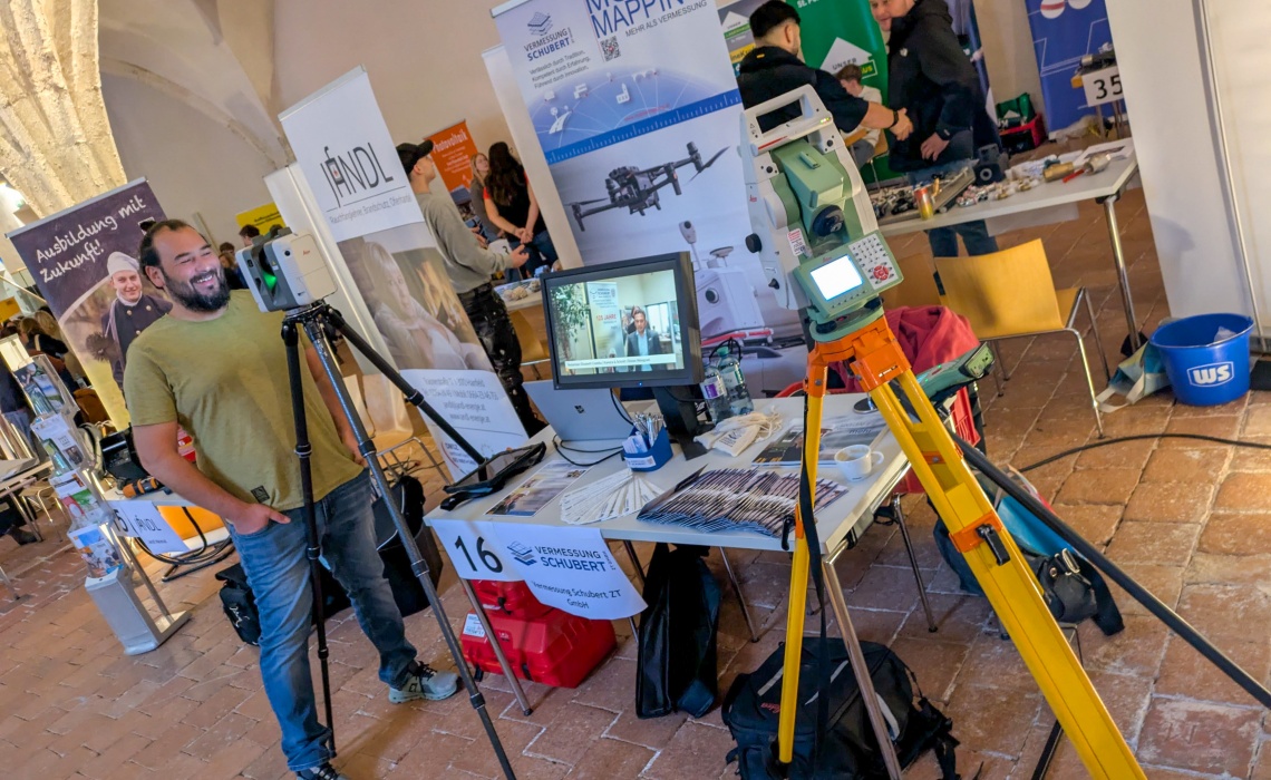 Ein Messestand mit verschiedenen Vermessungsgeräten, ein Mann links im Bild bedient eines davon.