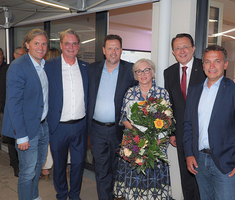 Gruppenfoto mit 6 Personen in Anzügen bzw. Kleid, 1 Person hält einen Blumenstrauß