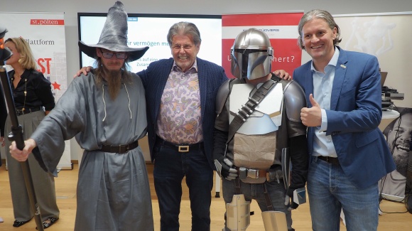 Gruppenfoto mit 4 Personen: 2 in Anzügen, die anderen beiden verkleidet als Zauberer und ScienceFiction Figur