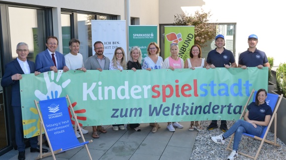 Personengruppe h&auml;lt gemeinsam ein buntes Werbetransparent